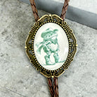 Bolo tie with decorative pendant featuring a frog in a cowboy hat on a concrete surface