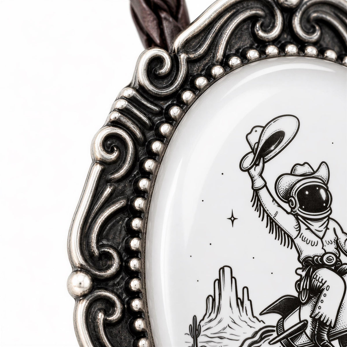 A close-up of a decorative metal frame with a black and white illustration of a cowboy riding a motorcycle, with mountains and stars in the background.