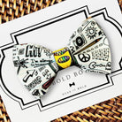 A bow tie with a colorful, hand-drawn design on it, placed on a white card with the text "BOLD BOWL" printed on it.