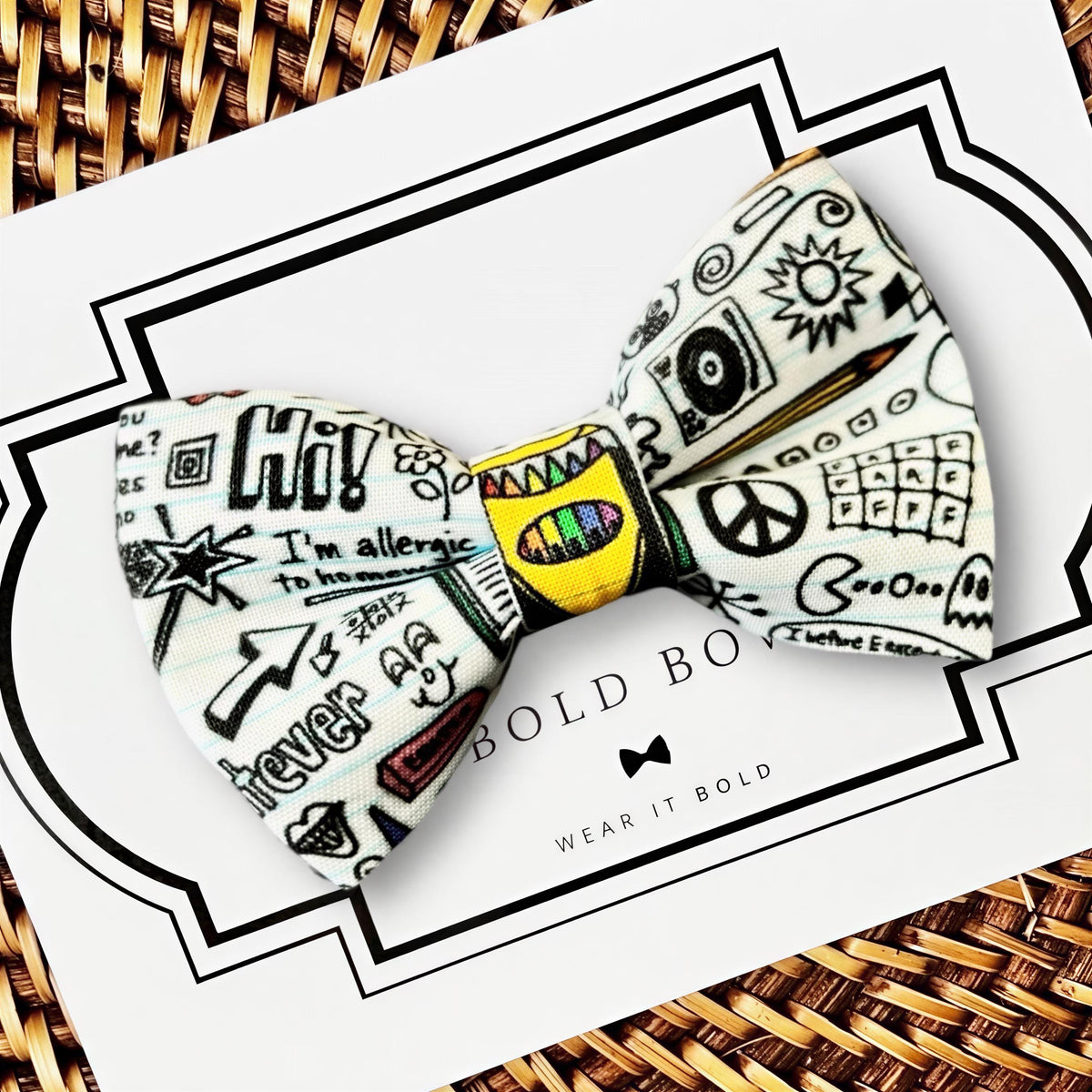 A bow tie with a colorful, hand-drawn design on it, placed on a white card with the text "BOLD BOWL" printed on it.