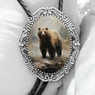 Bolo tie with a bear design in an ornate silver frame on a white background