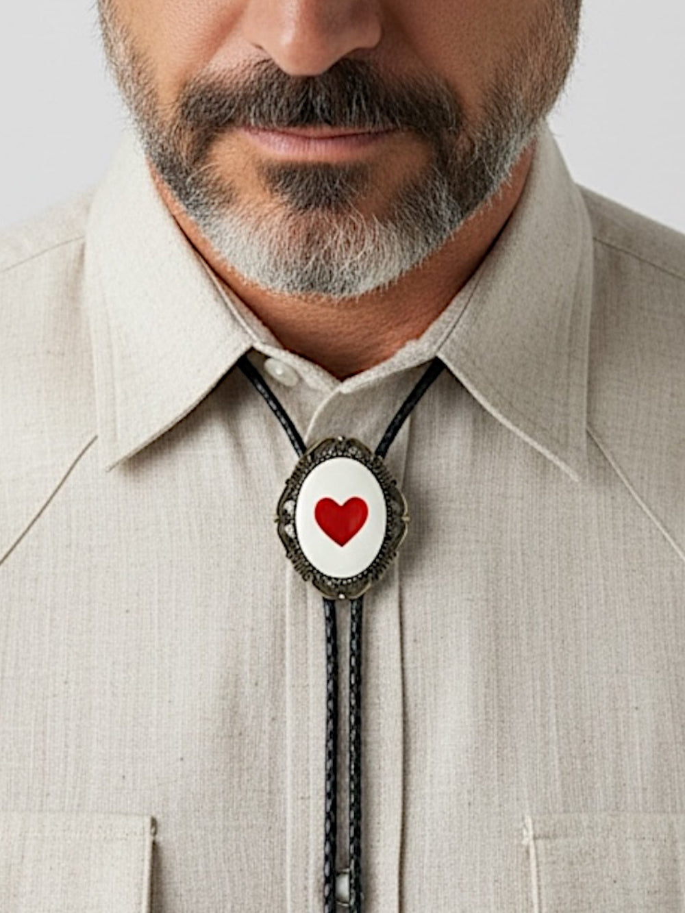 Bolo tie size chart from The Bold Bow Tie. The image displays a braided leather bolo tie with a round silver concho-style slide and silver metal tips, set against a multi-colored striped fabric background. A vertical dotted arrow on the right spans the full length of the piece, accompanied by text indicating a 39 inch cord length.