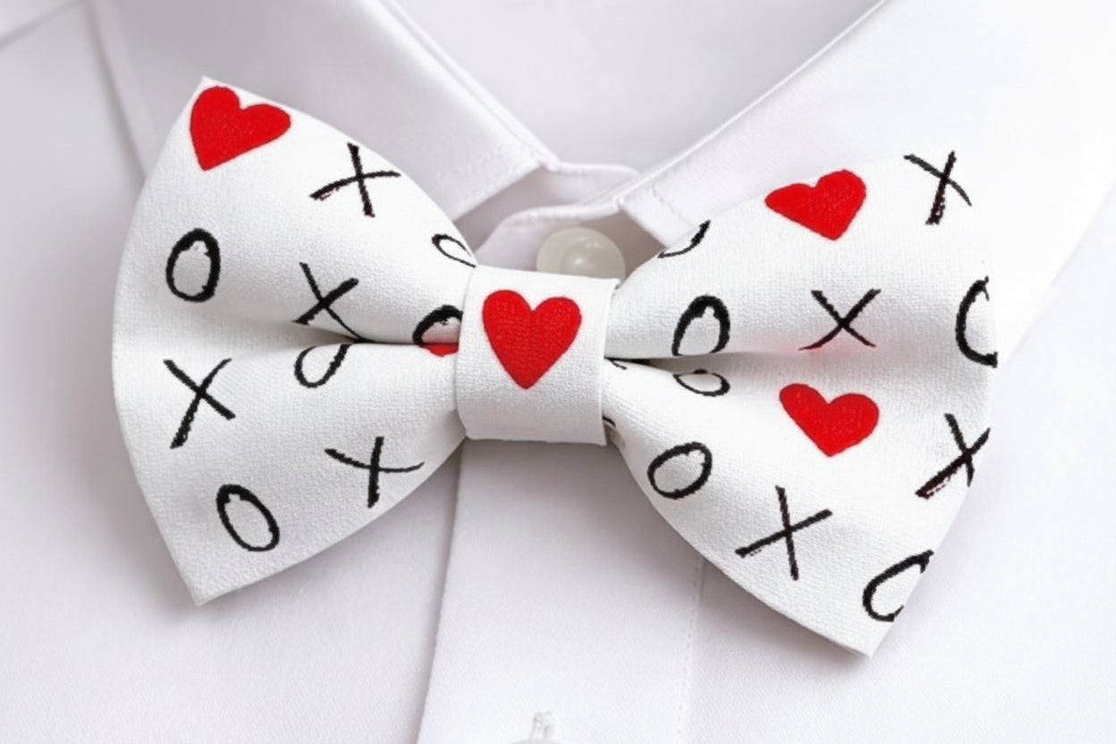 White Valentines Day bow tie with red hearts and black 'XO' pattern on a white shirt background