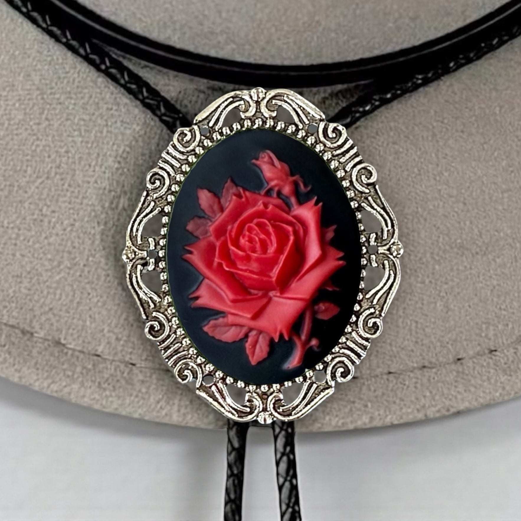 Bolo tie with red rose design on a beige hat