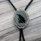Raven Bolo tie with a black silhouette of a bird on a gray background