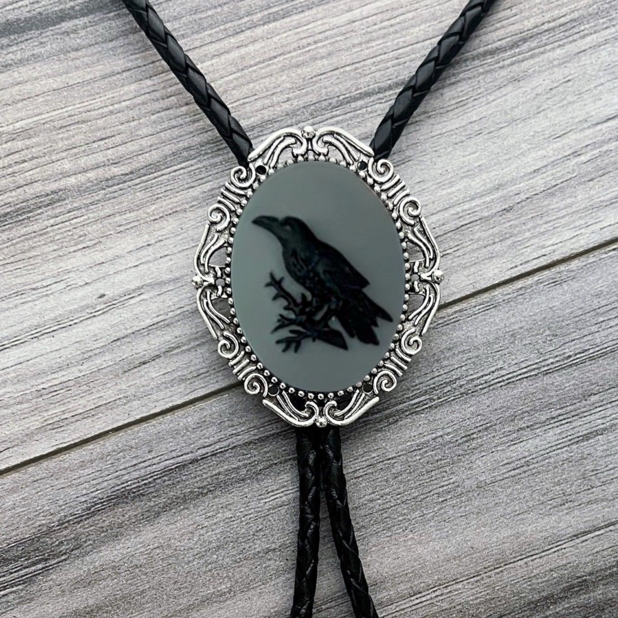 Raven Bolo tie with a black silhouette of a bird on a gray background