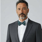 Navy floral bowtie for men worn by a groomsman in a suit for a wedding.