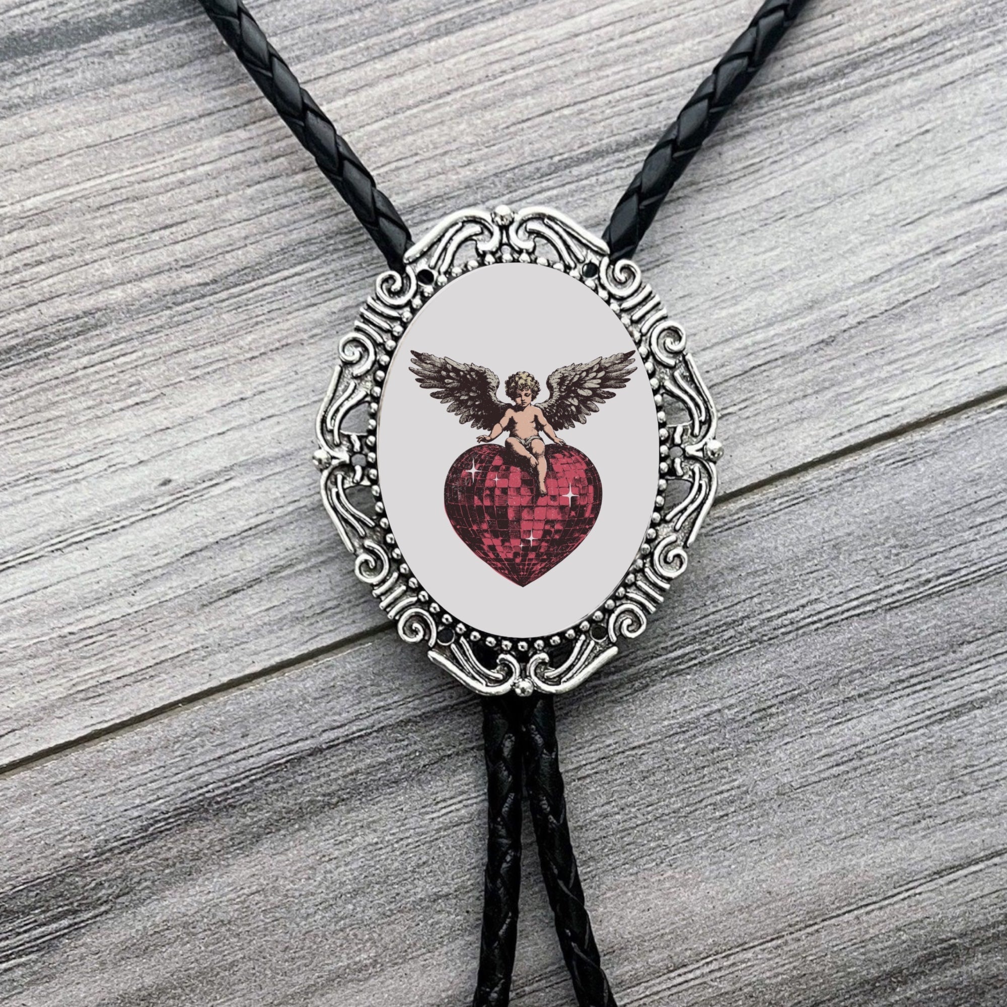Bolo tie with angel and heart design for Valentine’s Day on a wooden surface