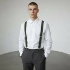 Groomsman wearing olive green suspenders for men and dark pants for a wedding.
