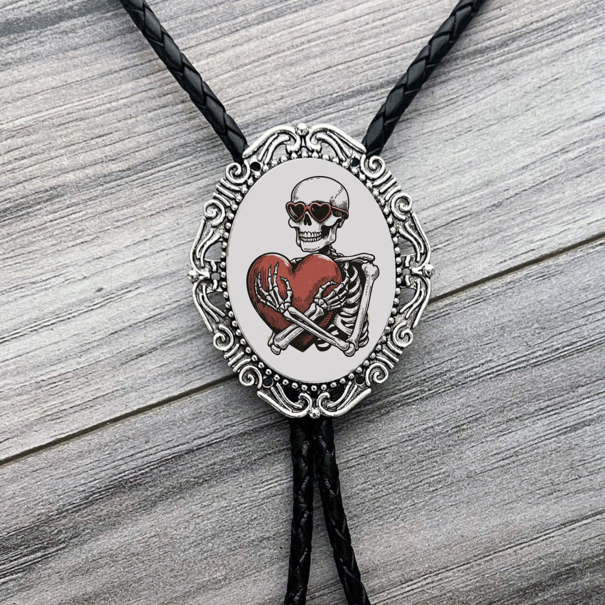 Bolo tie with skeleton and heart design for Valentine’s Day on a wooden surface