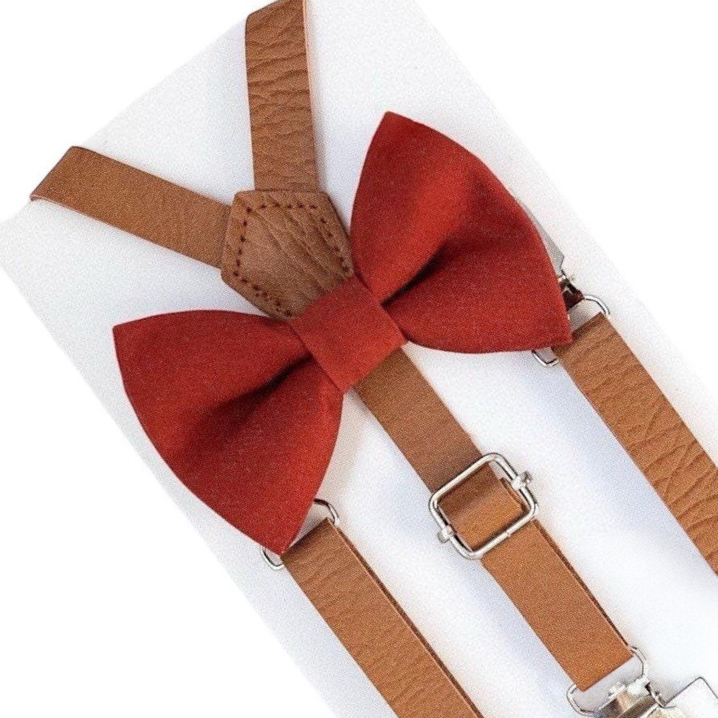 Burnt orange bow tie and brown suspenders on a white background