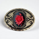 Decorative Cowboy belt buckle with red rose design on a white background