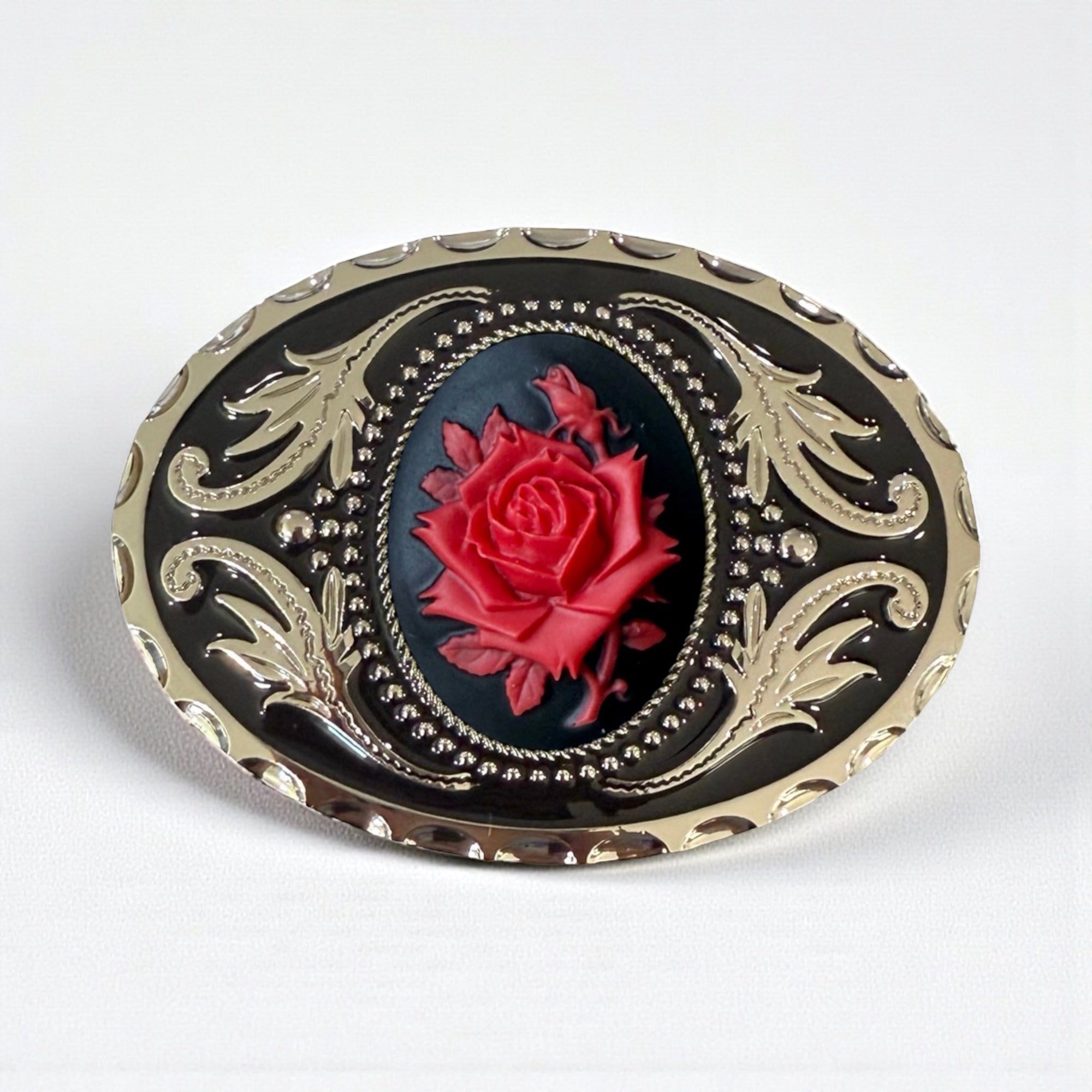 Decorative Cowboy belt buckle with red rose design on a white background