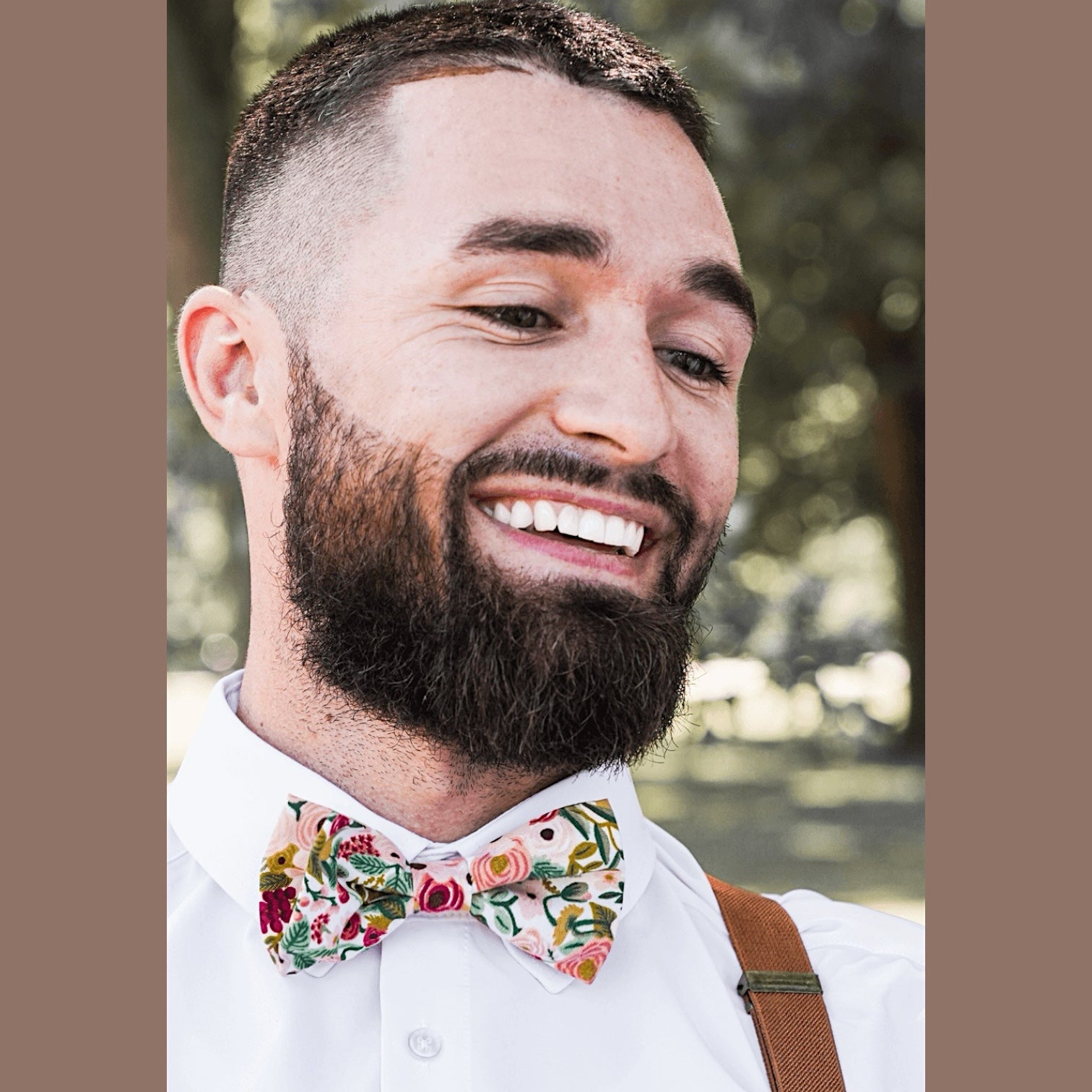 Groom wearing a burgundy maroon floral bow tie in rifle paper co fabric.