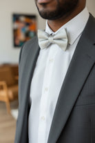 Groomsman wearing a silver bow tie at a wedding.