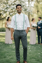 Groomsman In Sage Green Suspenders With Tan Leather Accents Standing Outdoor Wedding Attire Mens Formal Suit Accessory Rustic Style Handcrafted Braces