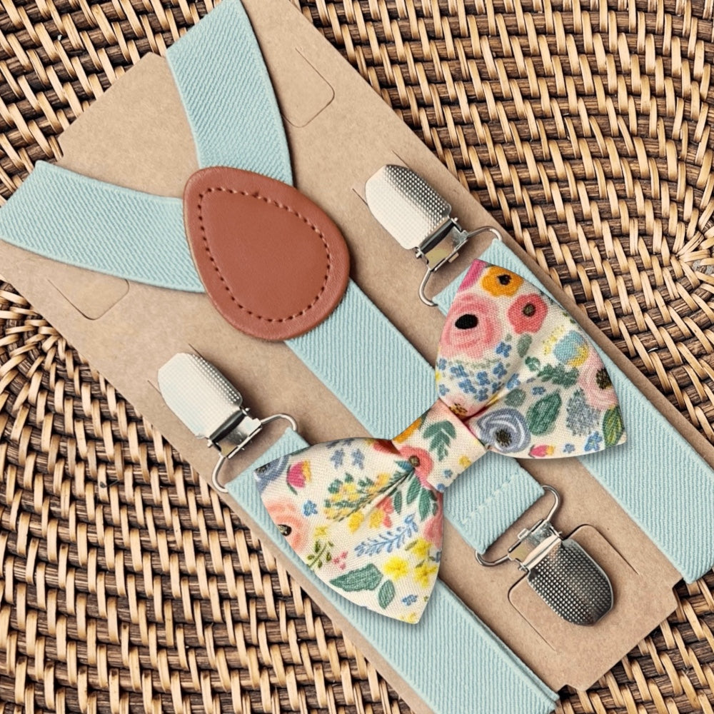 Floral groomsman bow tie and suspenders set on a woven surface