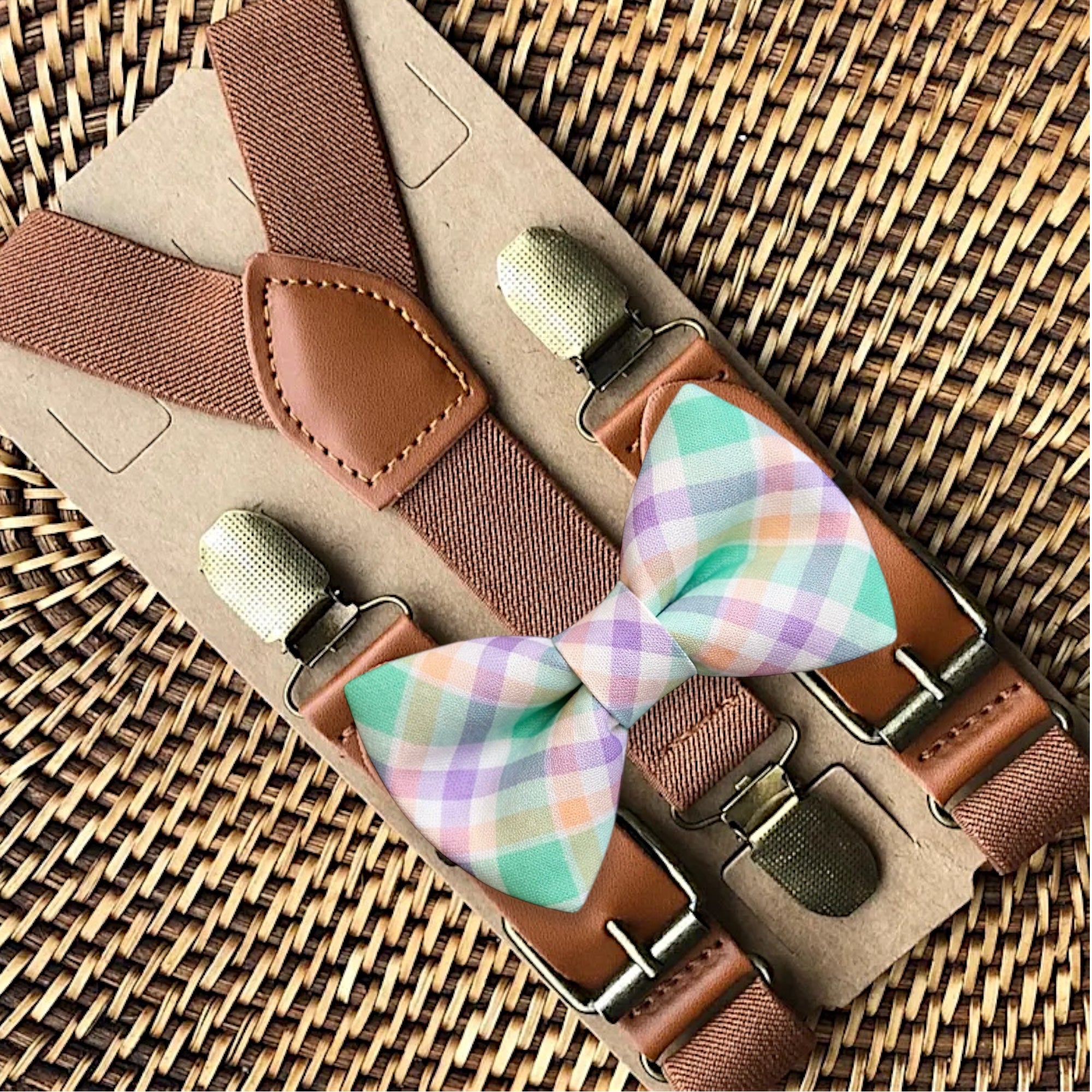 Close-up of a boys' Easter plaid bow tie and brown suspenders set featuring adjustable straps and high-quality metal clips.