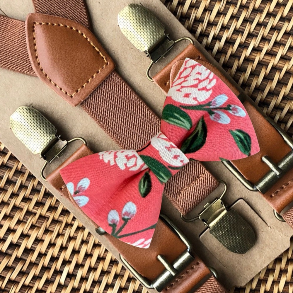 Pink floral bow tie and suspenders set on a woven surface