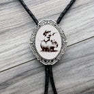 Funny western Bolo tie with capybara and mouse design on a wooden surface