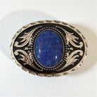 Decorative belt buckle with blue stone and intricate silver design on a white background