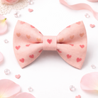 Pink bow tie with heart patterns on a white background with flowers and ribbons.
