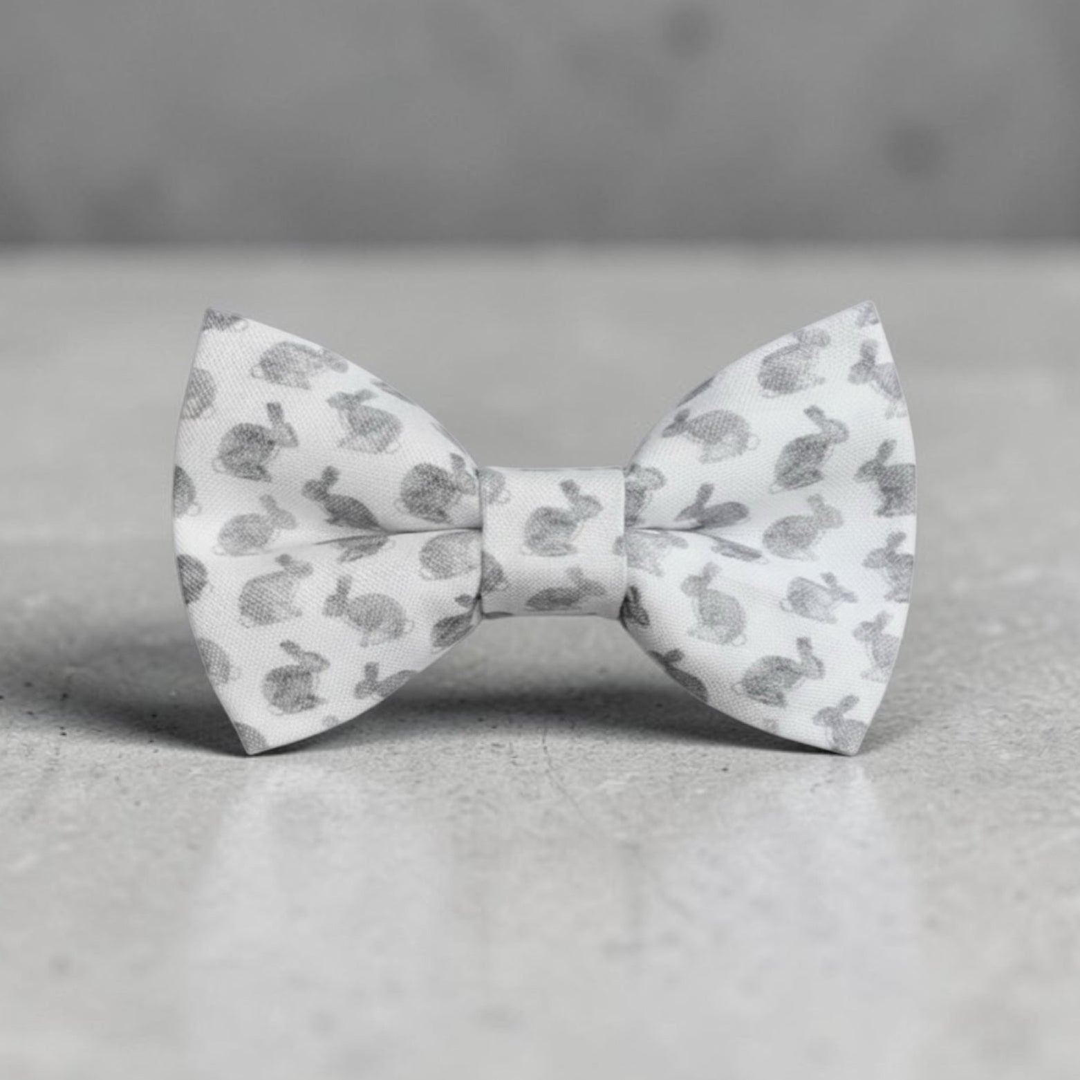 White Easter toddler bow tie with gray pattern on a gray surface.