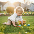 Child wearing a light blue seersucker Easter bow tie playing with Easter eggs in a grassy yard