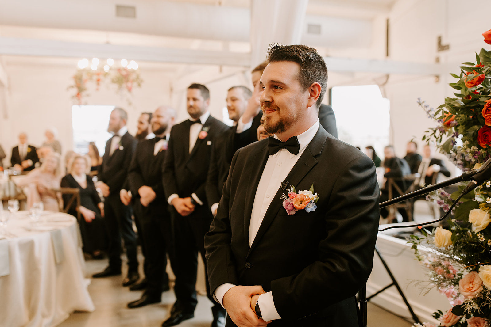 Satin black bow tie being worn by a groom at a wedding.