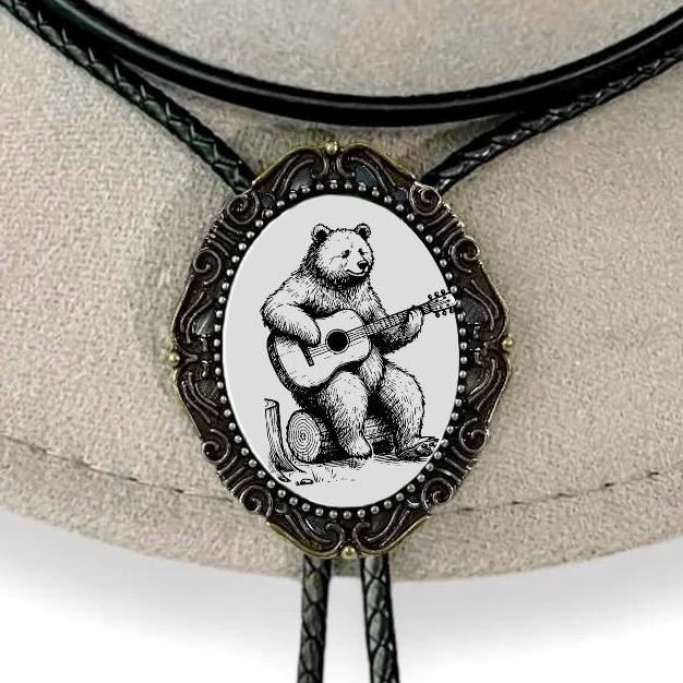 Bolo tie with bear playing guitar design on a beige background
