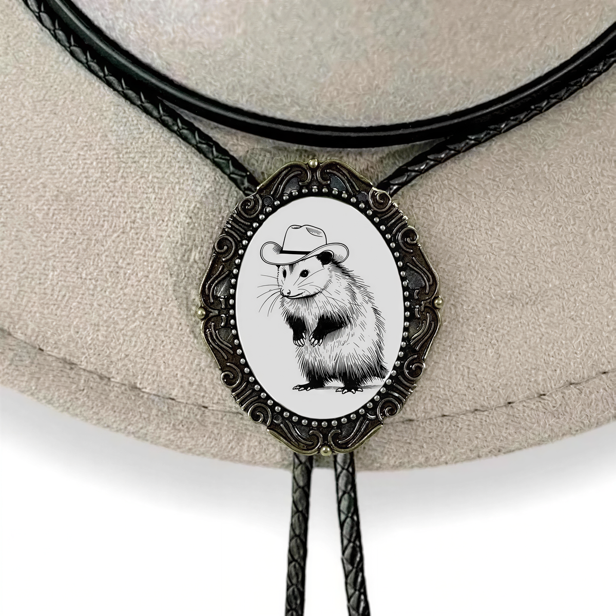 A close-up of a decorative biker or cowboy hat pin featuring a small illustration of a rodent wearing a hat.