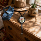 Vibrant flower bouquet bronze setting cowboy fashion decorative aglets wood grain backdrop.