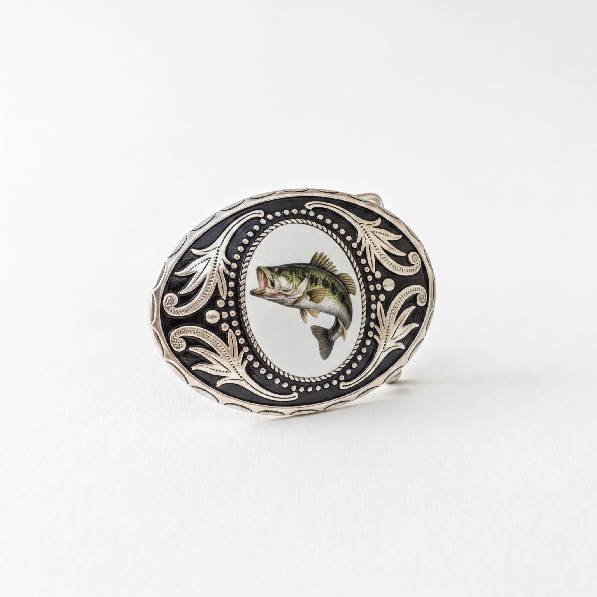 A decorative metal buckle featuring a fish image within an ornate frame.