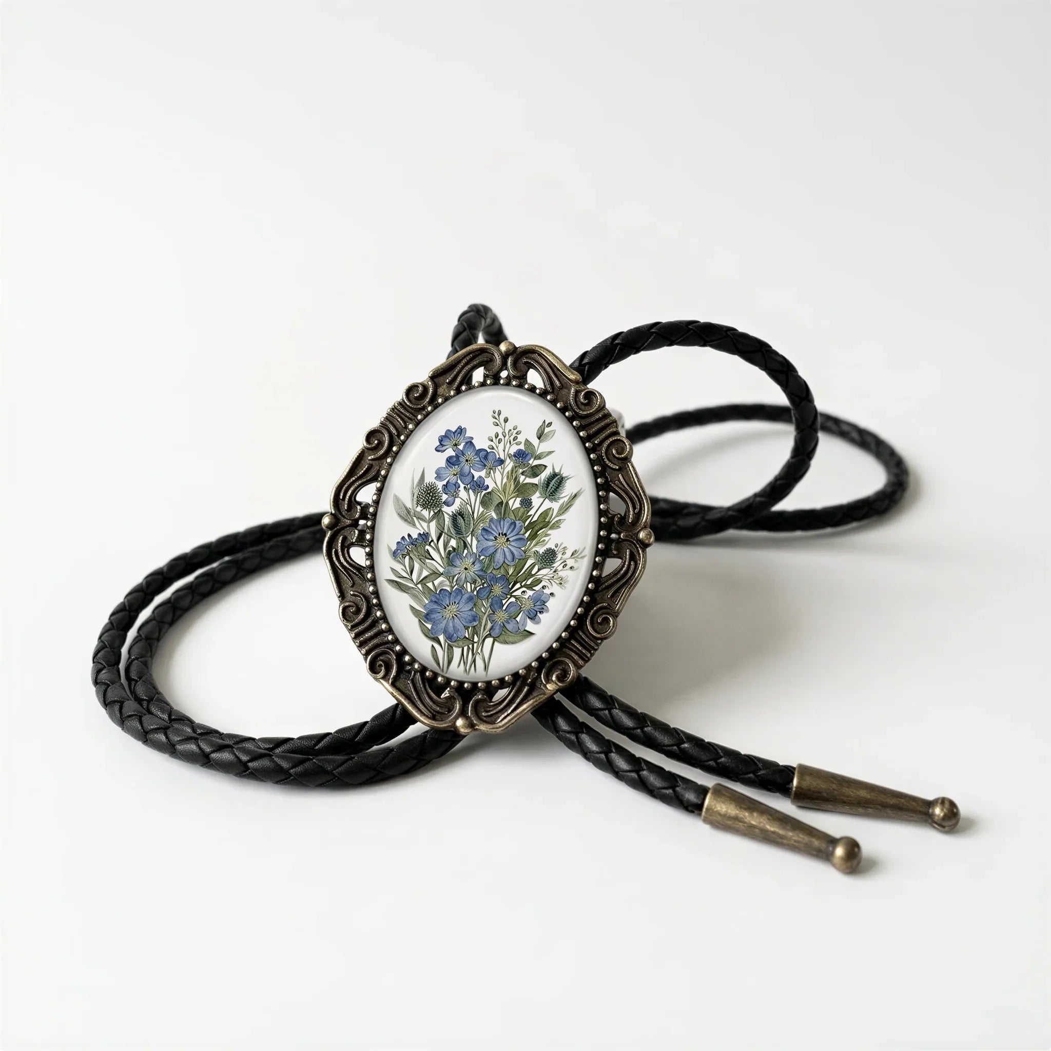 A decorative pendant featuring a floral design is displayed on a black leather cord.