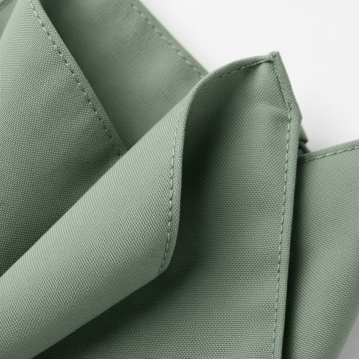 A close-up view of a green fabric, possibly a napkin or tablecloth, with a slight crease visible.