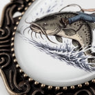 A close-up of a decorative metal frame with a fish illustration on it.