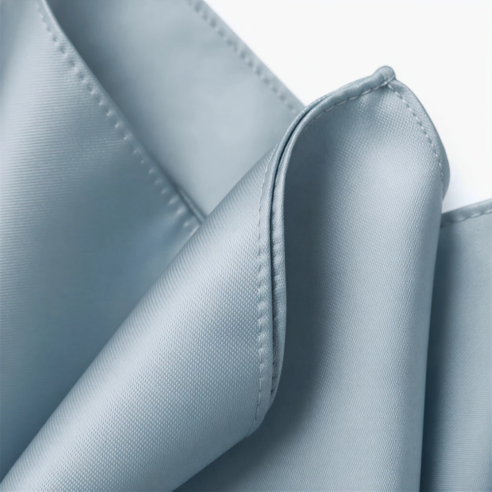 A close-up view of a light blue fabric, possibly a piece of clothing or a decorative item, with a slightly curled and folded appearance.