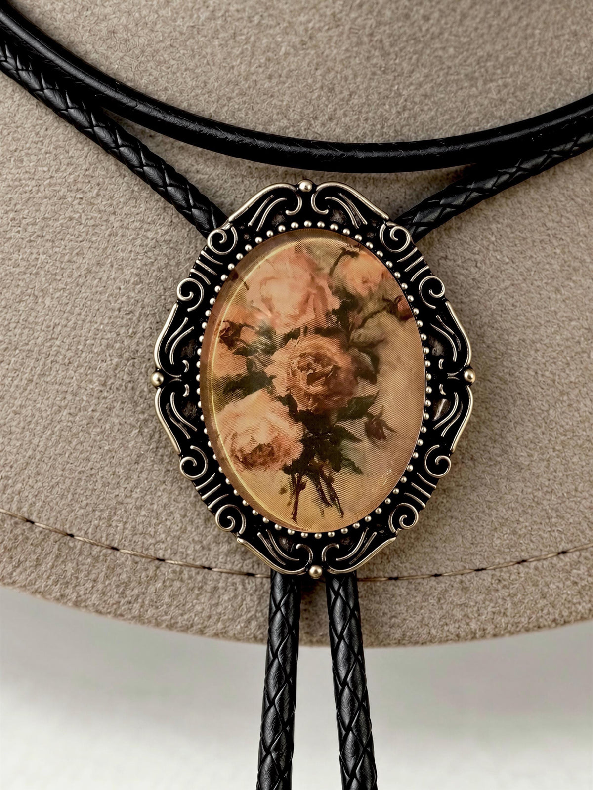 Classic romantic rose bouquet bronze setting cowboy attire decorative aglets wood grain backdrop.