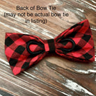 A red and black plaid bow tie is displayed on a wooden surface, with text indicating that it may not be an actual bow tie in a listing.