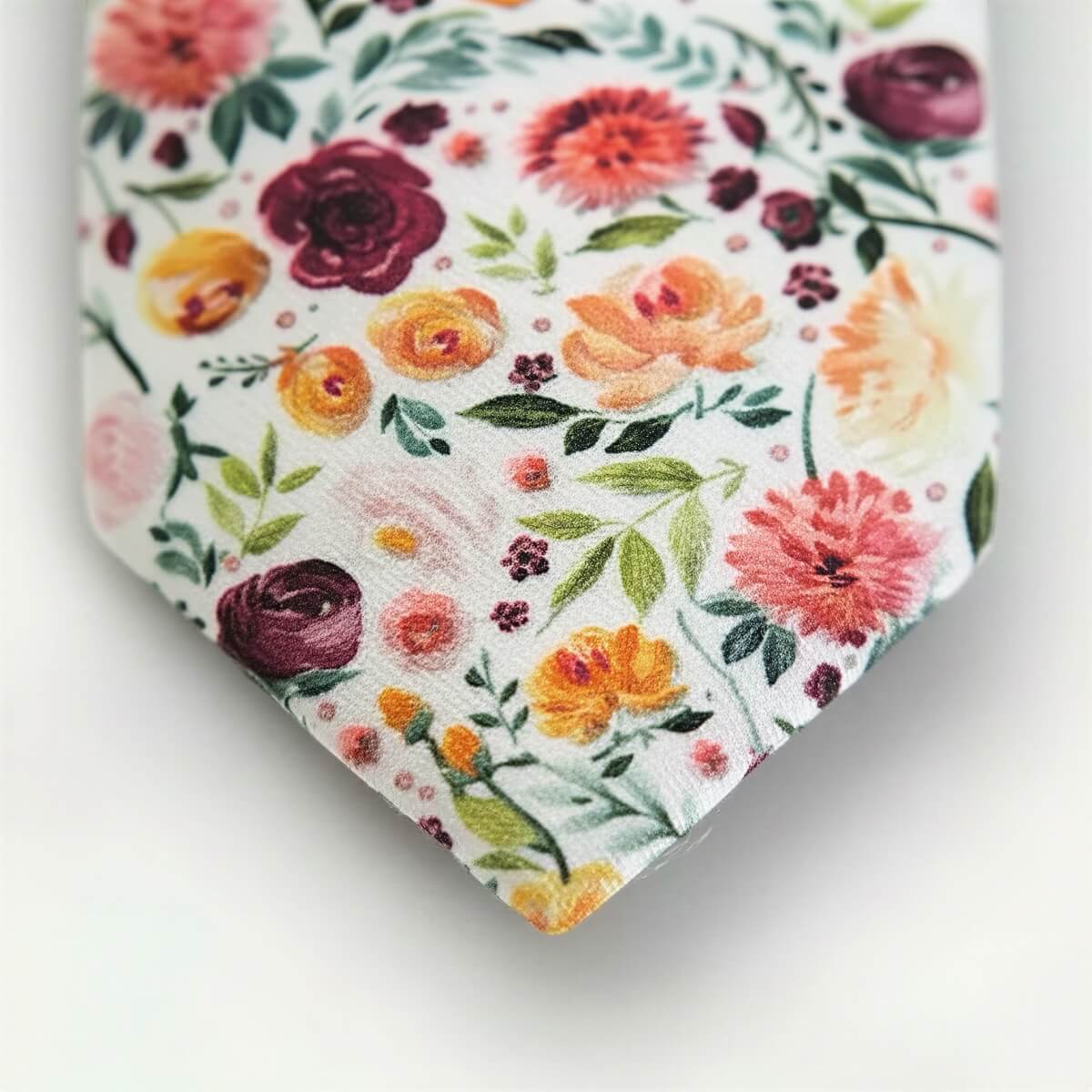 a close-up view of a tie with a floral pattern, including various types of flowers and leaves.