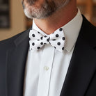 Polka dot bowtie on a man in a suit.