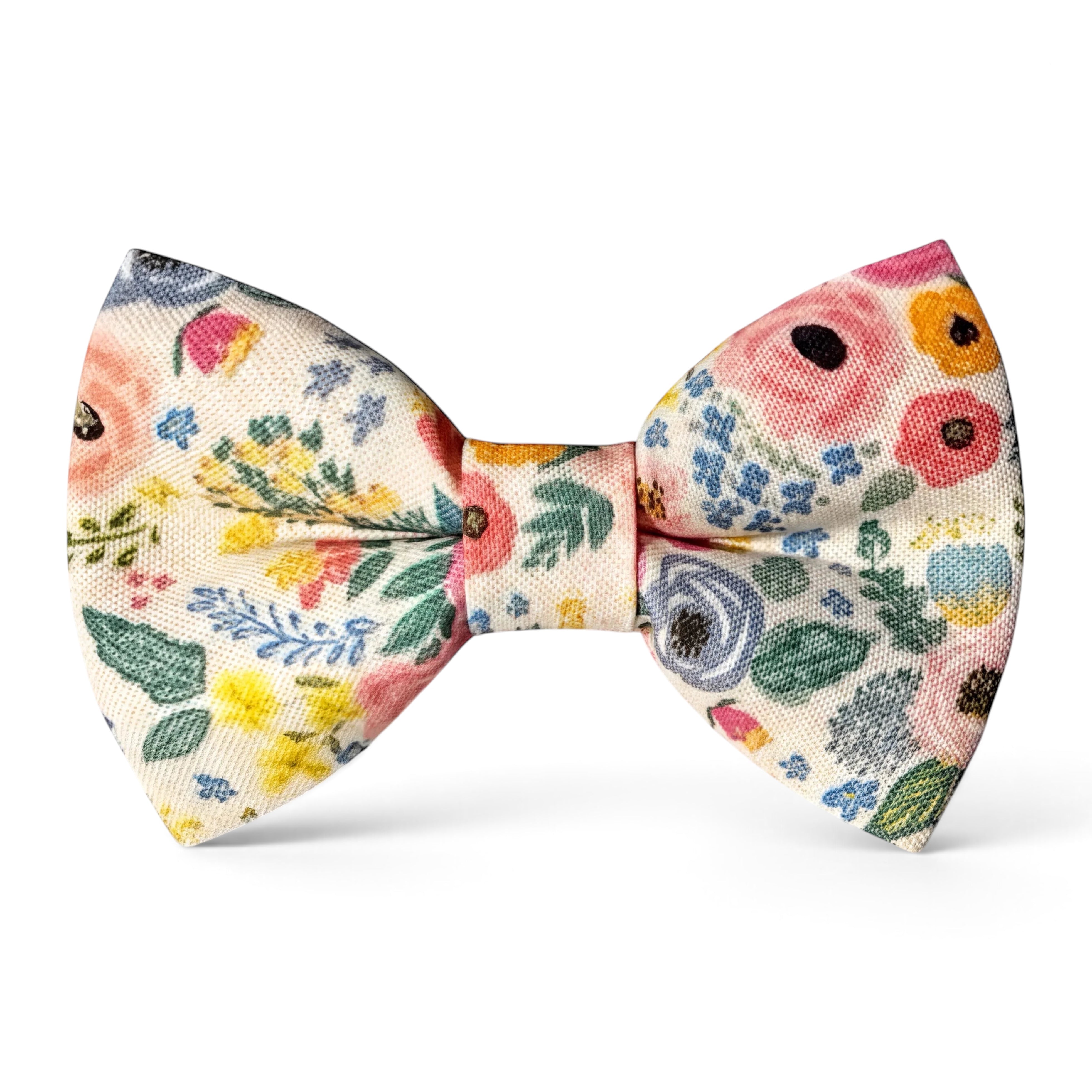 The Bold Bow Tie pre-tied cotton bow tie featuring a vibrant floral print with pink, yellow, and blue flowers.
