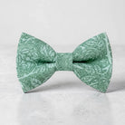 The Bold Bow Tie sage green cotton pre-tied bow tie featuring a delicate floral pattern for rustic weddings