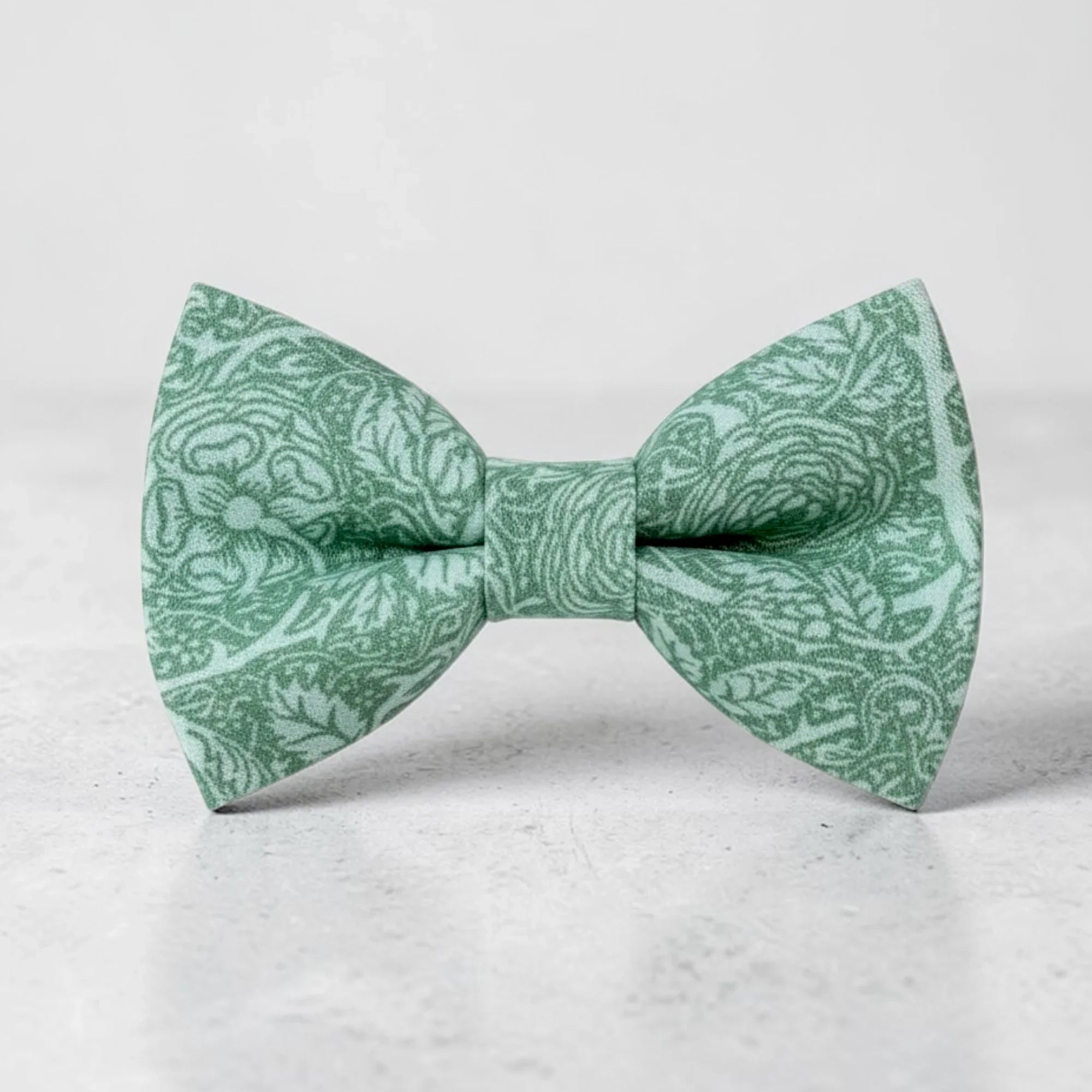 The Bold Bow Tie sage green cotton pre-tied bow tie featuring a delicate floral pattern for rustic weddings