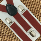 The Bold Bow Tie terracotta wedding suspenders with silver metal clips and a black leather back patch on display.