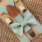 a blue bow tie and suspenders on a piece of cardboard