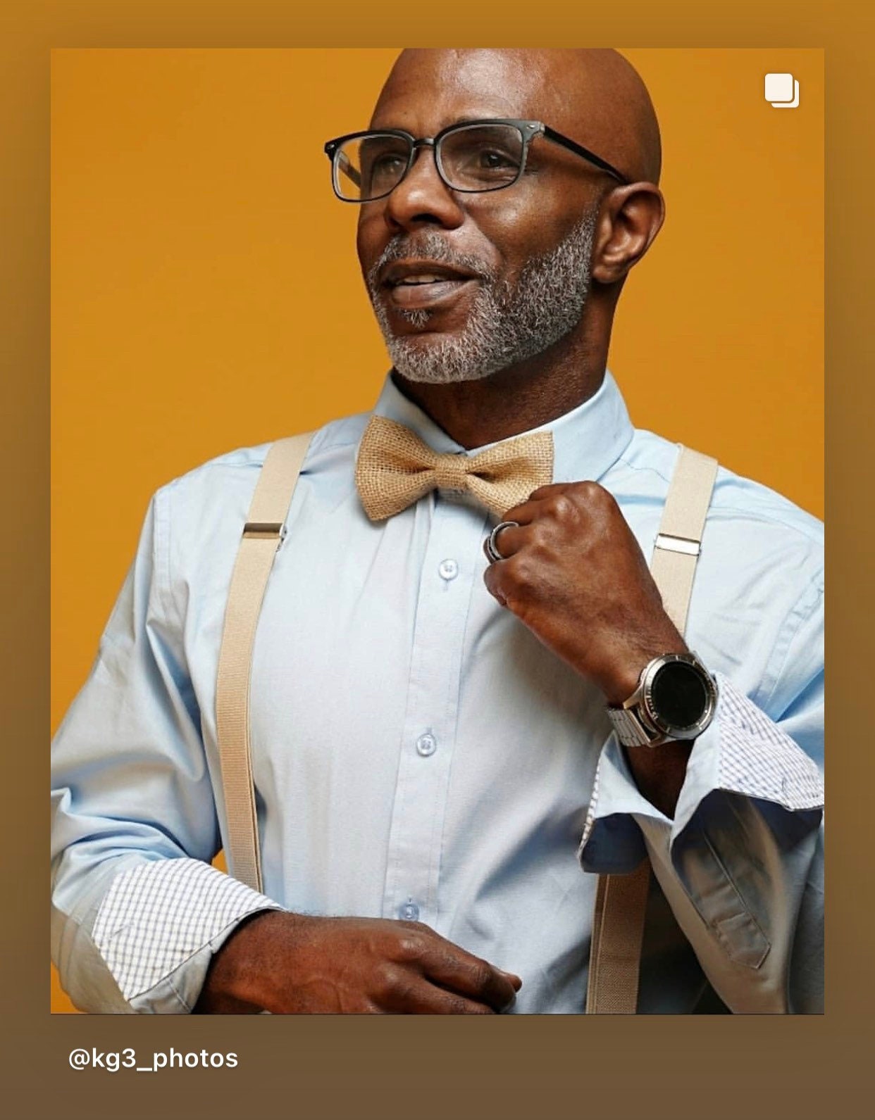 A handsome model wears a country chic burlap bow tie and rustic tan suspenders for a cowboy wedding. 